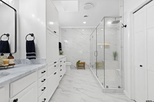 a bathroom with a double vanity sink mirror and shower