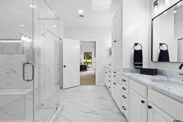 a bathroom with a granite countertop sink mirror and shower