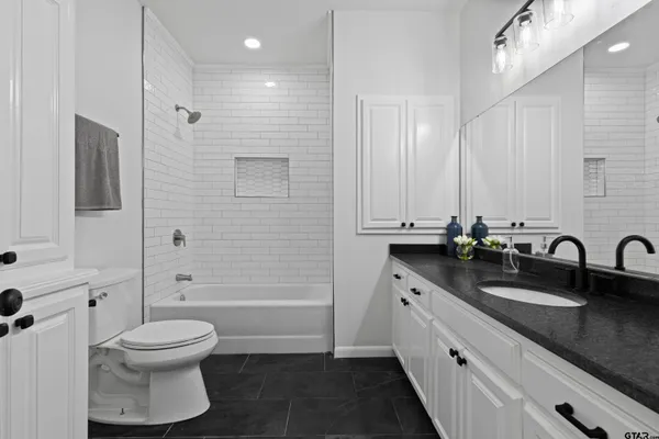 a bathroom with a double vanity sink toilet and shower