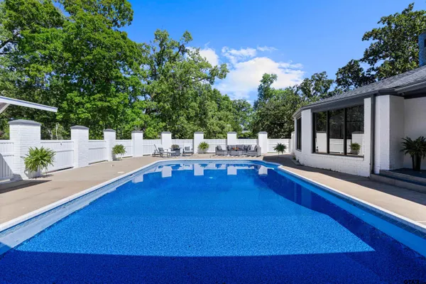 a swimming pool with outdoor seating and yard