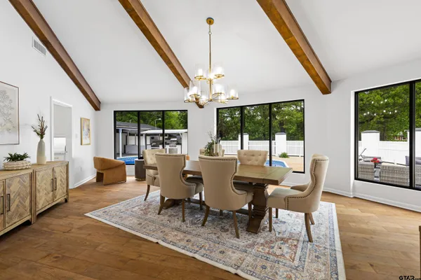 a dining room with furniture a chandelier and wooden floor