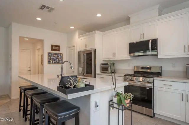 a kitchen with stainless steel appliances kitchen island granite countertop a stove a sink and a microwave