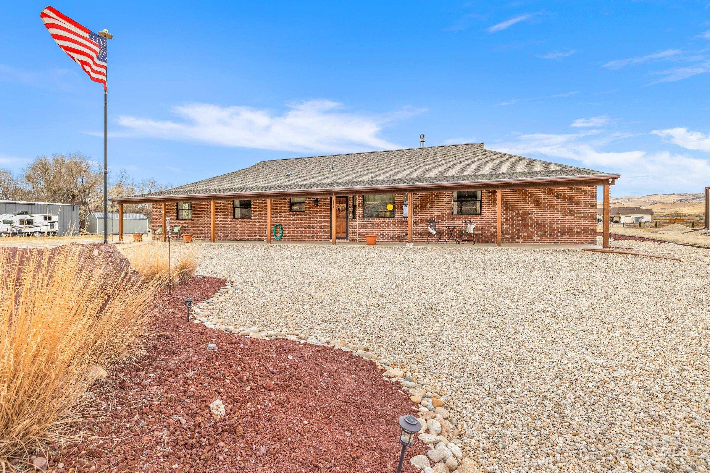 10514 Airpark Loop Road Melba, ID 83641 - Photo 38 of 47 Back of house featuring roof with shingles, brick siding, and a patio
