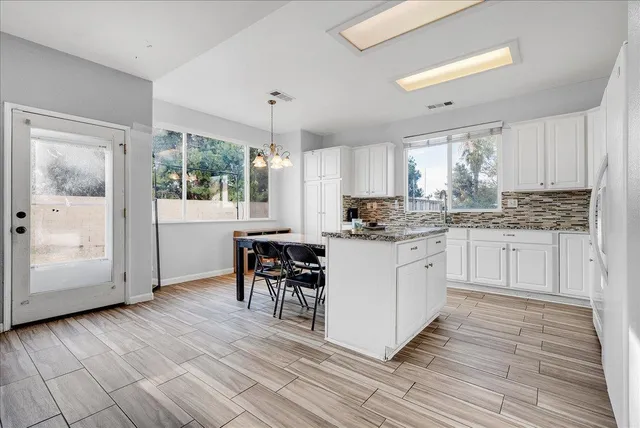 a kitchen with white cabinets and white appliances