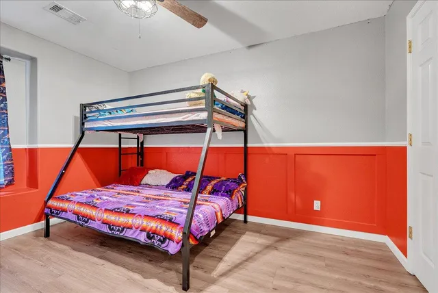 a bedroom with a bed and wooden floor