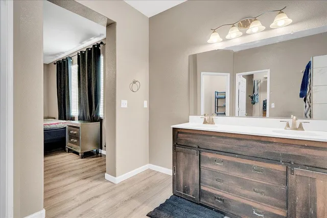 a bathroom with a double vanity sink and a mirror