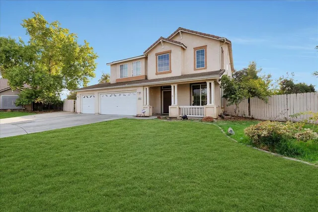 a front view of a house with a garden and yard