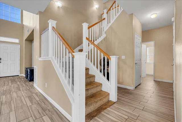 a view of staircase with lots of frames on wall and wooden floor