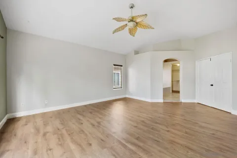 a view of an empty room with window and wooden floor