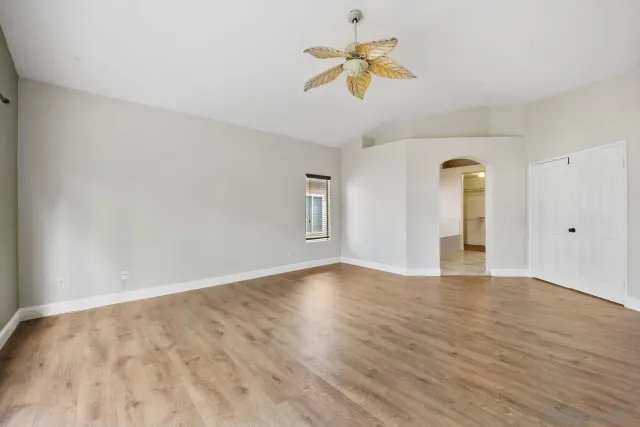 a view of an empty room with window and wooden floor