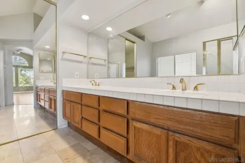 a spacious bathroom with double sink and a large mirror