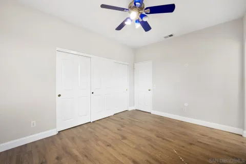 a view of a room with wooden floor and chandelier fan