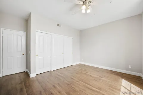 a view of a room with wooden floor and a ceiling fan