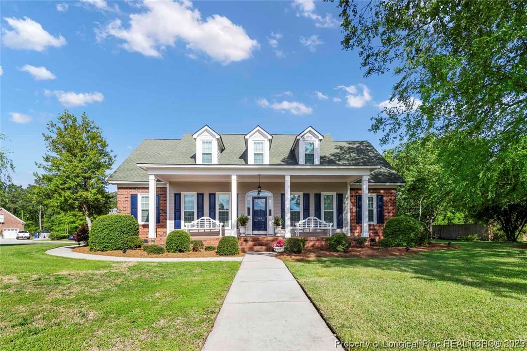 a front view of a house with yard and green space