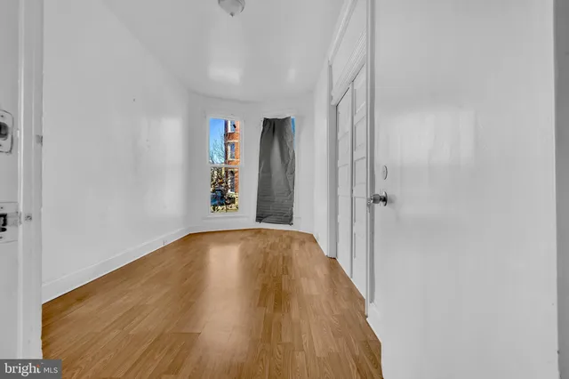 a view of a hallway with wooden floor and closet