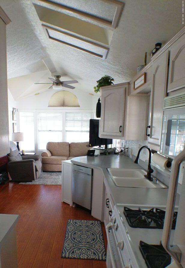 84136 Ave 44, Unit 628 Indio, CA 92203 - Photo 26 of 34 a kitchen with a sink a stove and a wooden floor