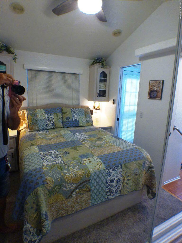84136 Ave 44, Unit 628 Indio, CA 92203 - Photo 29 of 34 a bedroom with a bed and wooden floor