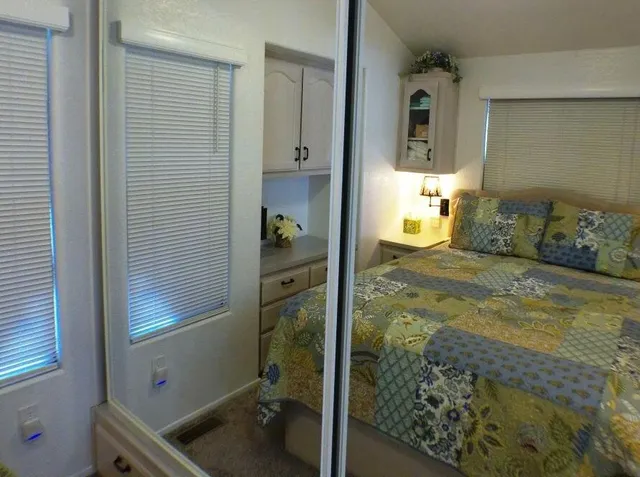 a kitchen with stainless steel appliances kitchen island granite countertop a refrigerator a sink a stove and white cabinets