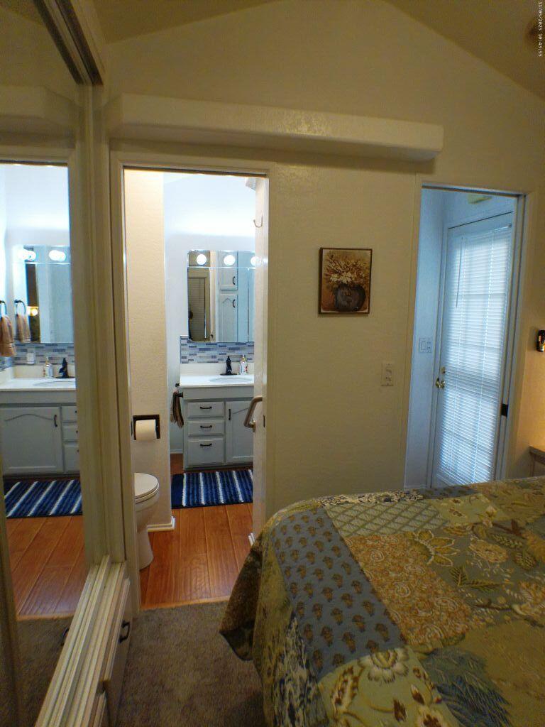 84136 Ave 44, Unit 628 Indio, CA 92203 - Photo 33 of 34 a bedroom with a bed and a view of en suite bathroom