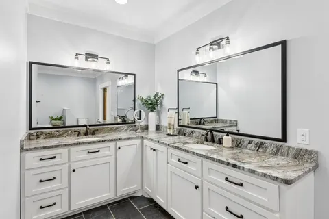 a bathroom with a granite countertop sink a toilet and a mirror