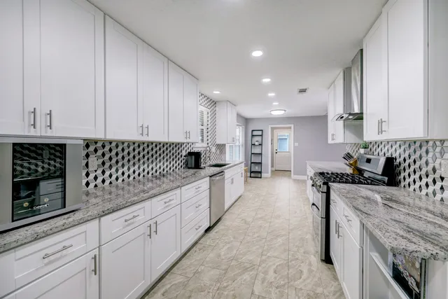 a kitchen with granite countertop a sink and cabinets
