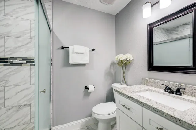 a kitchen with a refrigerator and white cabinets