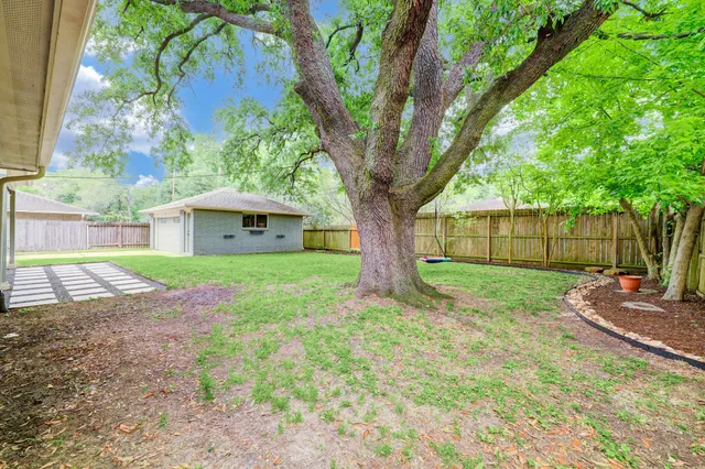 a white house that has a tree in front of it