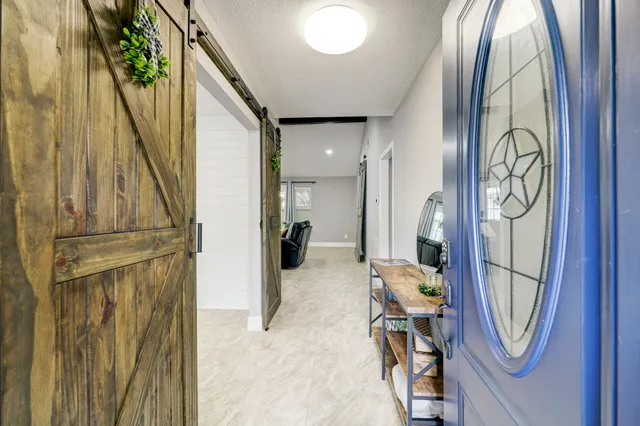 a view of a hallway with wooden floor and staircase