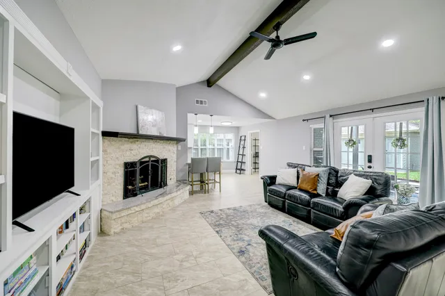 a living room with furniture a flat screen tv and a fireplace