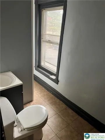 a bathroom with a toilet a sink and mirror