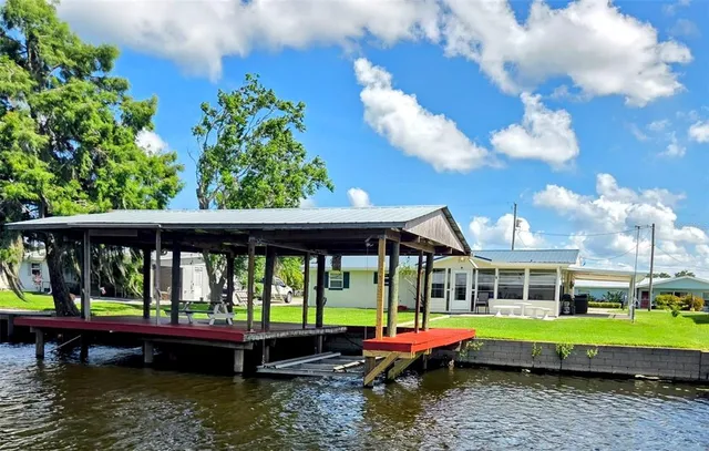 a view of swimming pool with lawn chairs and a yard