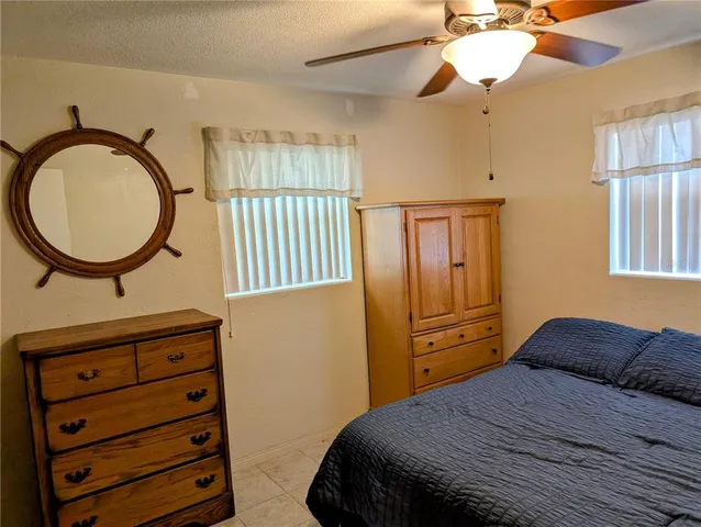 a bedroom with a bed a dresser and a chandelier