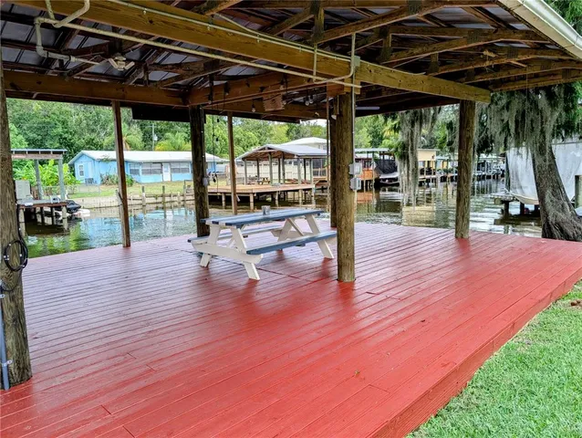 a patio with wooden floor a yard tables and chairs