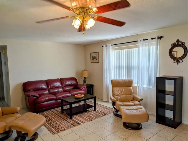 a living room with furniture a ceiling fan and a rug
