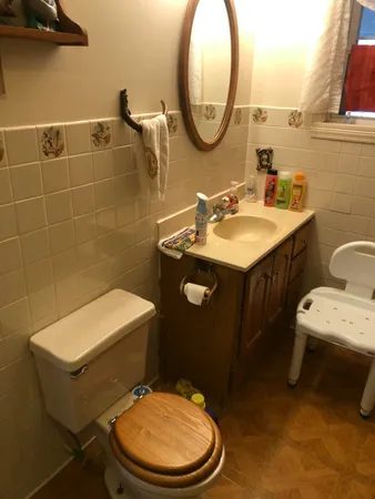 a bathroom with a granite countertop toilet a sink and a mirror