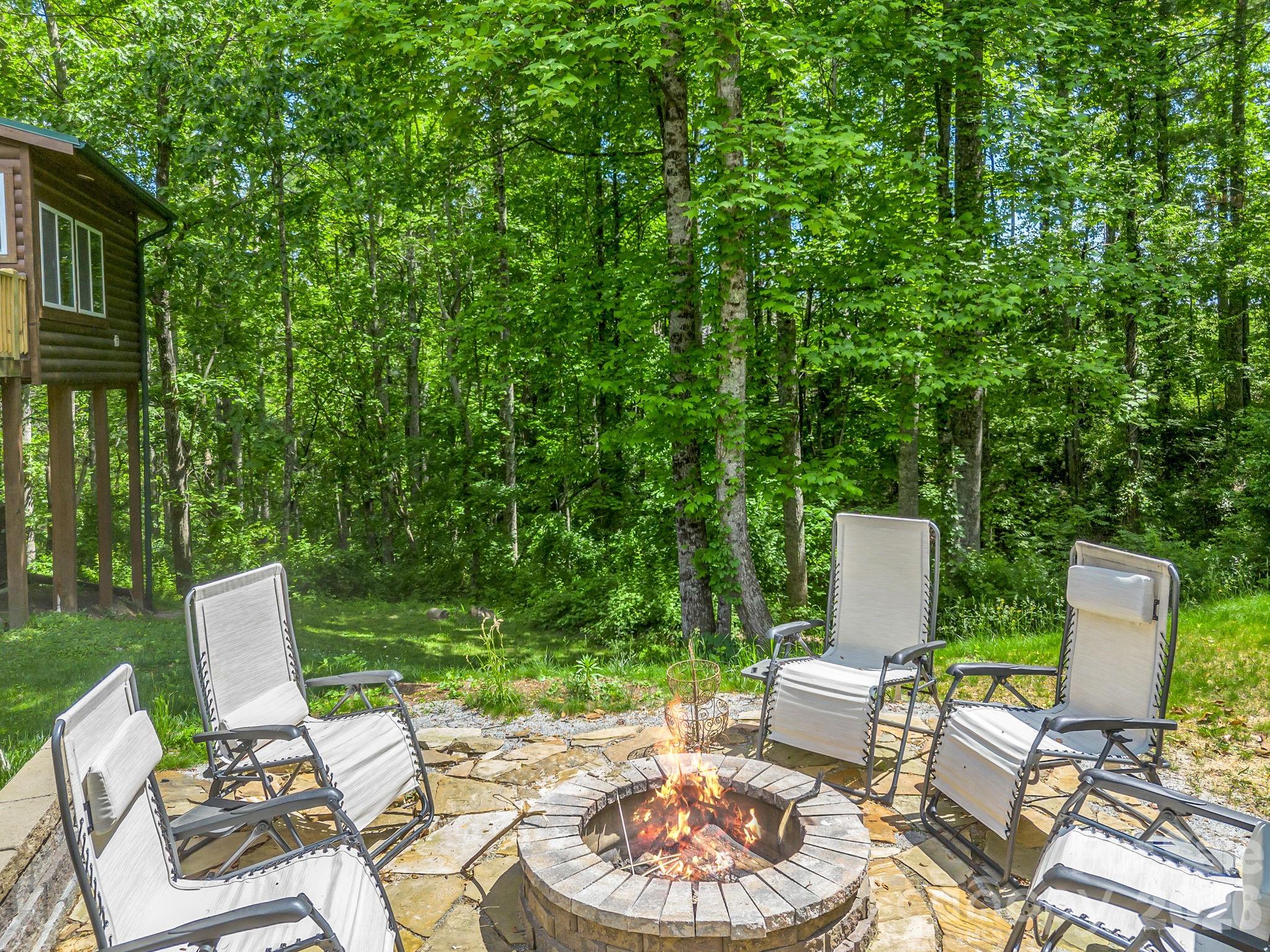165 Dream Road Hendersonville, NC 28792 - Photo 38 of 46 a view of a patio with table and chairs and a barbeque with potted plants