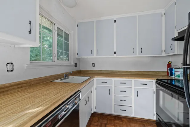 a kitchen with granite countertop a sink stove and cabinets