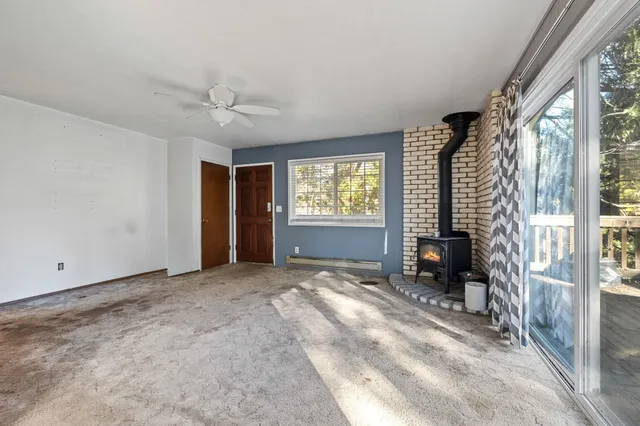 a view of an empty room with a window and a kitchen