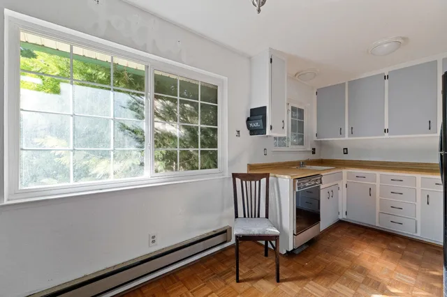 a kitchen with a stove a sink and a window