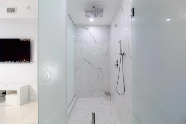 a bathroom with a shower and a glass door