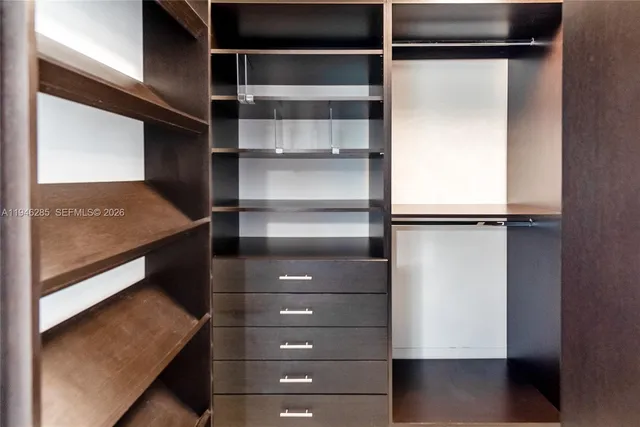 a view of walk in closet with empty racks