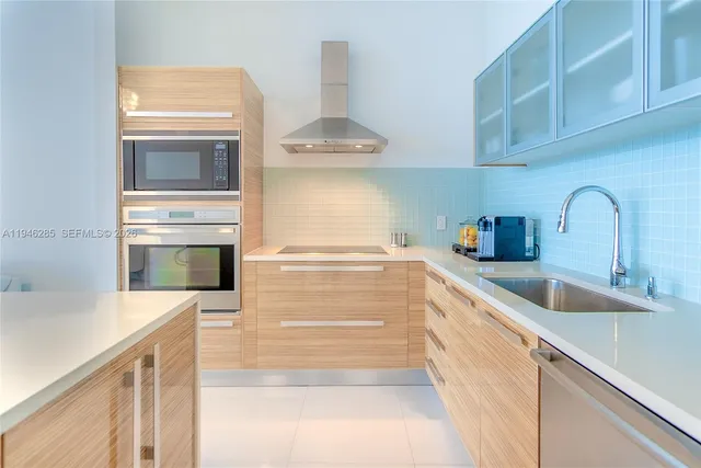 a kitchen with stainless steel appliances a stove and a sink
