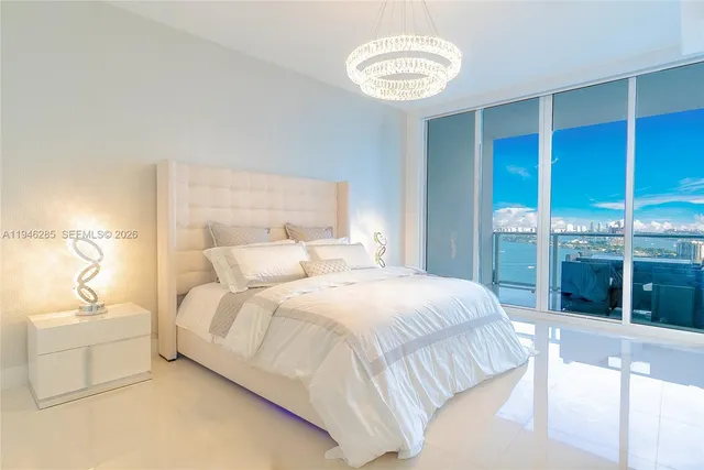 a bedroom with a large bed and a chandelier