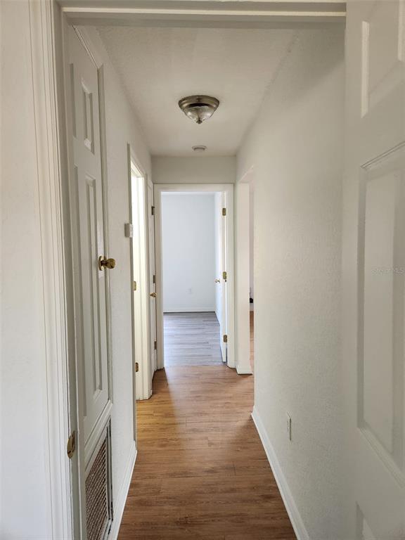 10154 Henderson Street Spring Hill, FL 34608 - Photo 11 of 19 a view of a hallway with wooden floor