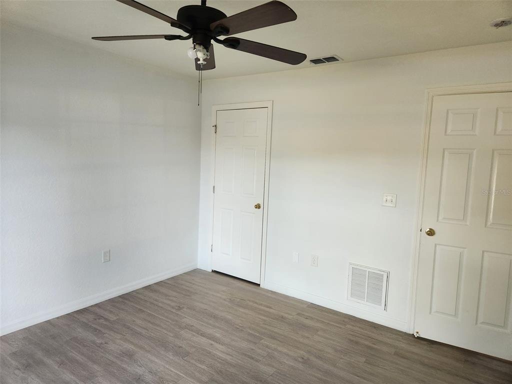 10154 Henderson Street Spring Hill, FL 34608 - Photo 12 of 19 a view of an empty room with wooden floor