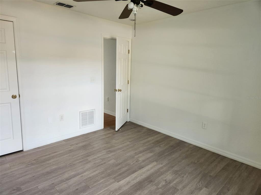 10154 Henderson Street Spring Hill, FL 34608 - Photo 13 of 19 a view of an empty room with wooden floor