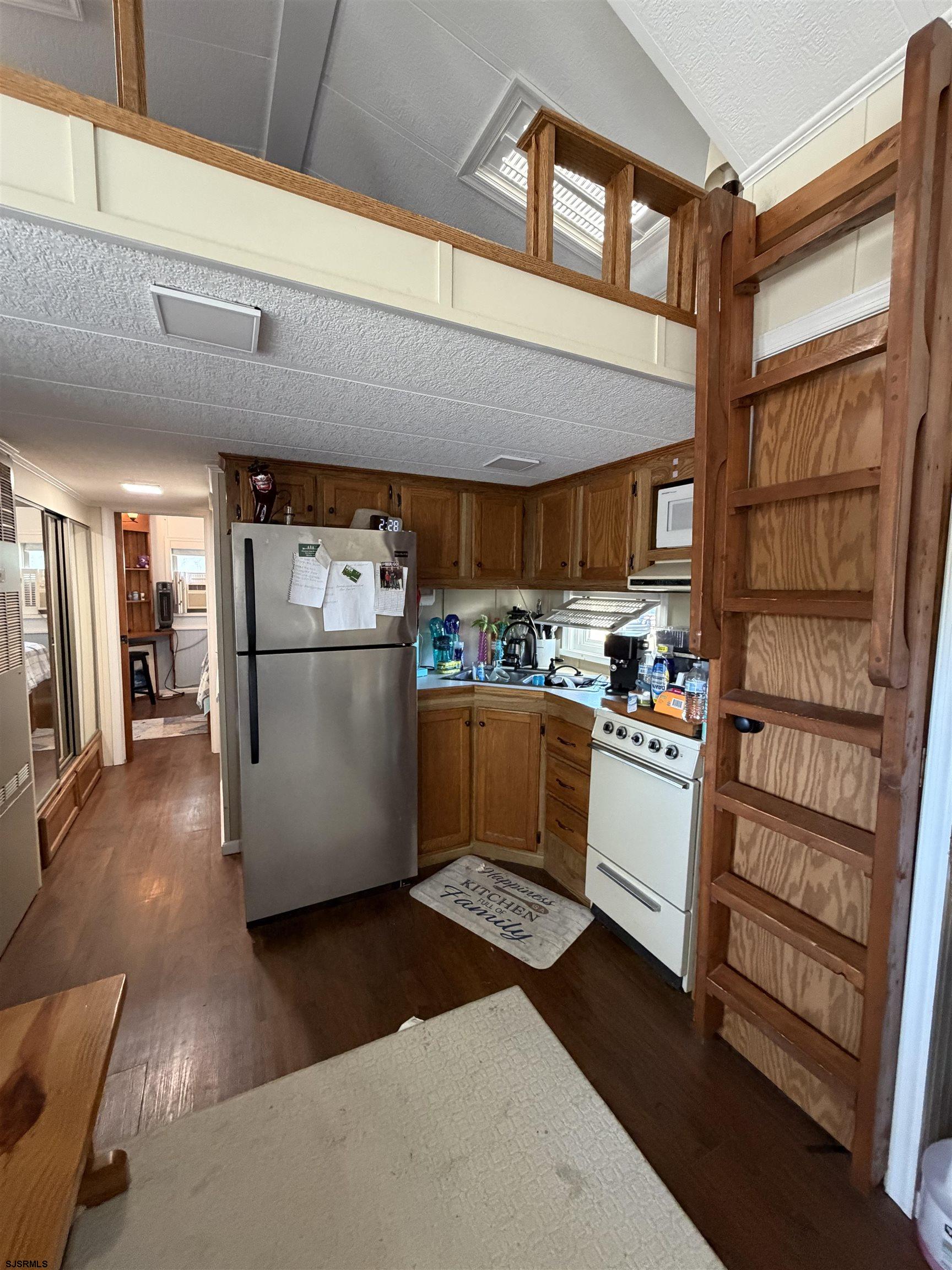 631 Chestnut Neck Road Port Republic, NJ 08241 - Photo 5 of 13 a kitchen with stainless steel appliances kitchen island granite countertop a refrigerator a stove and a sink with wooden floor