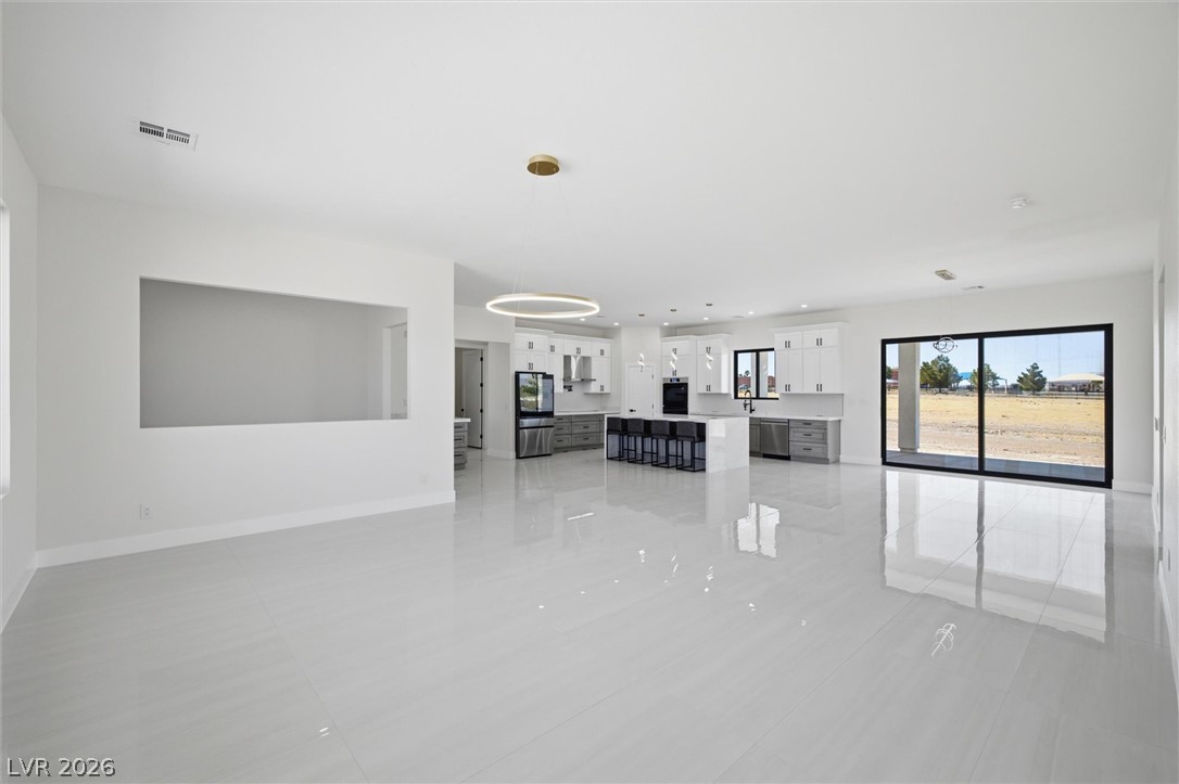 5910 East Kellogg Road Pahrump, NV 89061 - Photo 13 of 58 A spacious, open-concept interior seamlessly blends kitchen and living areas with a view of the outdoors.