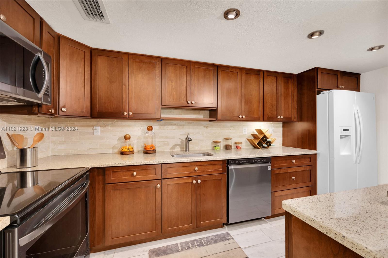 a kitchen with stainless steel appliances granite countertop a refrigerator sink and cabinets