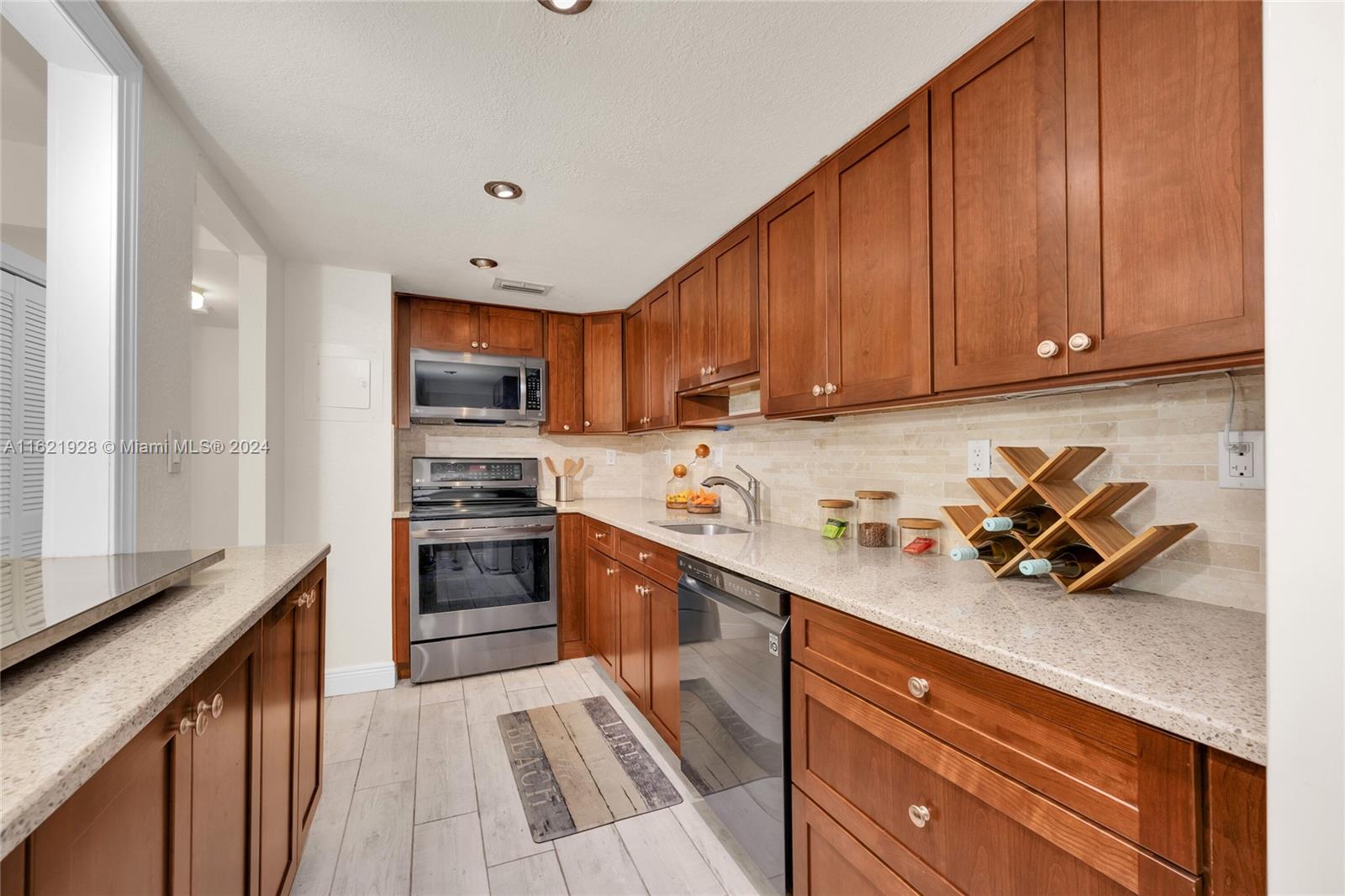 7927 Southwest 104th Street, Unit 108E Miami, FL 33156 - Photo 2 of 17 a kitchen with a sink a stove and cabinets